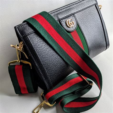 black gucci handbag with red and green strap